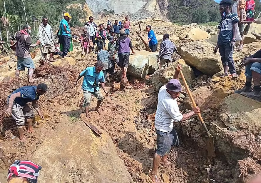 Pessoas escavando para tentar encontrar as pessoas soterradas
