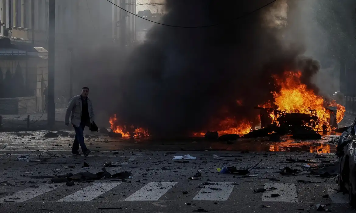 Imagem de homem na rua em frente ao hospital bombardeado