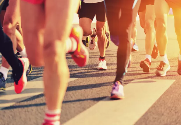 Imagem das pernas de pessoas correndo uma maratona